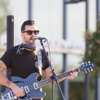 Jesse Ray signing and playing guitar on stage.